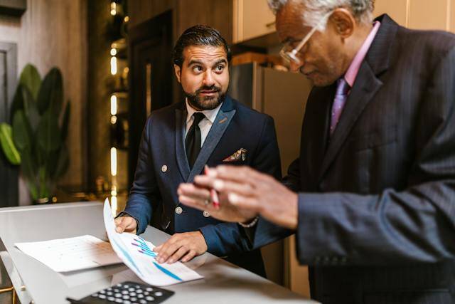 two realtor talking while holding a document